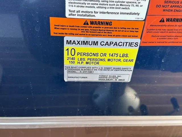 Slide: The Image of 2015 Xcursion X21F capacity label: 10 persons, 1475 lbs, 2140 lbs with motor, 150 HP. - 25