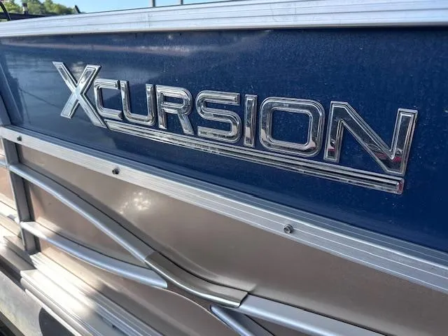 Slide: The Image of 2015 Xcursion X21F boat, close-up of metallic logo on blue exterior. - 4