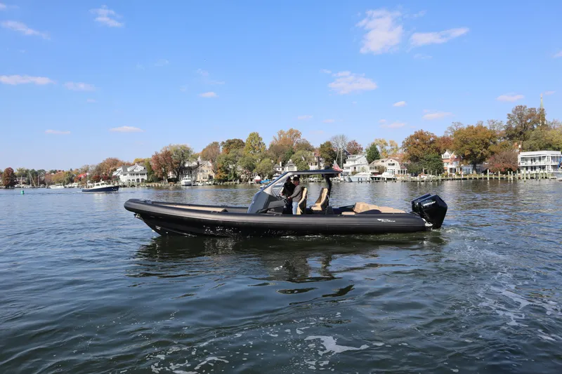 Slide: The Image of 2023 Ribco Seafarer 36 X boat cruising on a scenic lake with autumn foliage. - 1