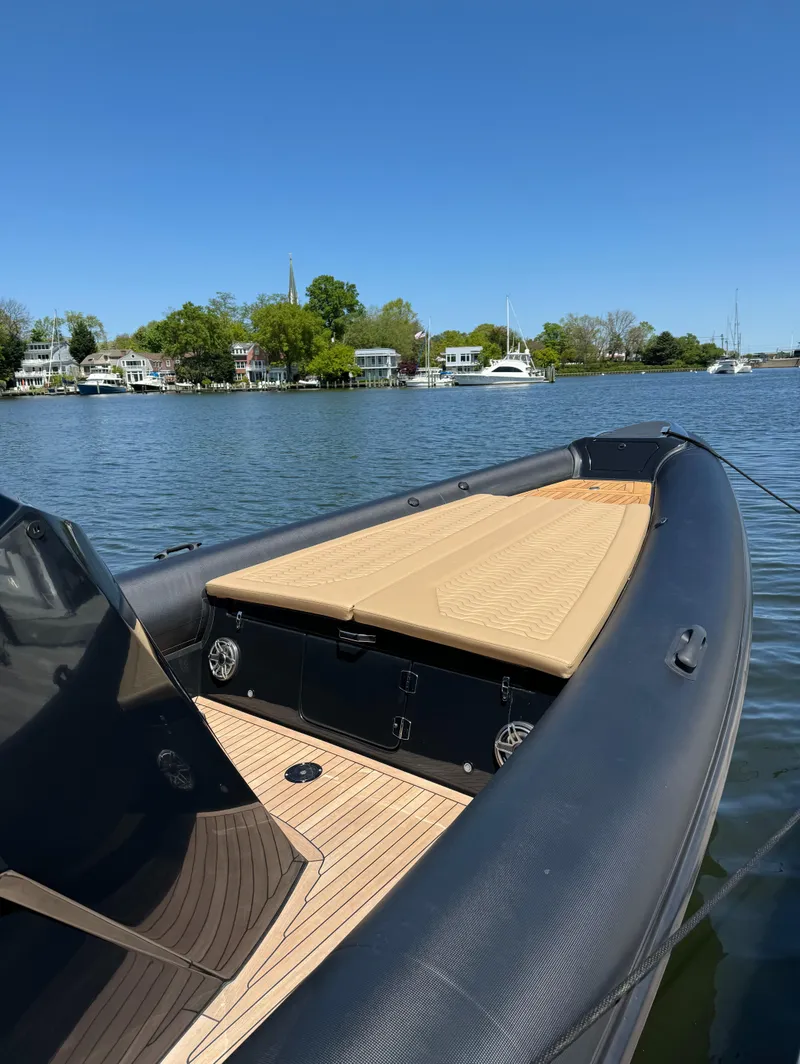 Slide: The Image of 2023 Ribco Seafarer 36 X boat on calm water, with scenic waterfront homes. - 13