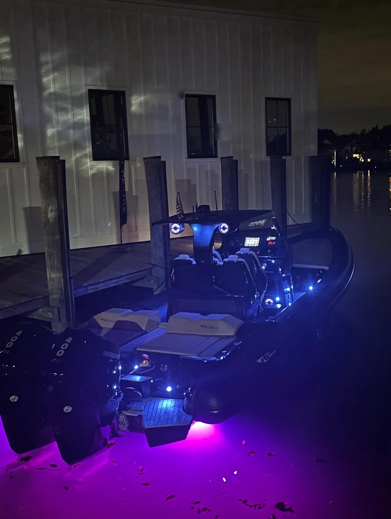 Slide: The Image of 2023 Ribco Seafarer 36 X boat with vibrant blue and purple LED lights at night. - 14