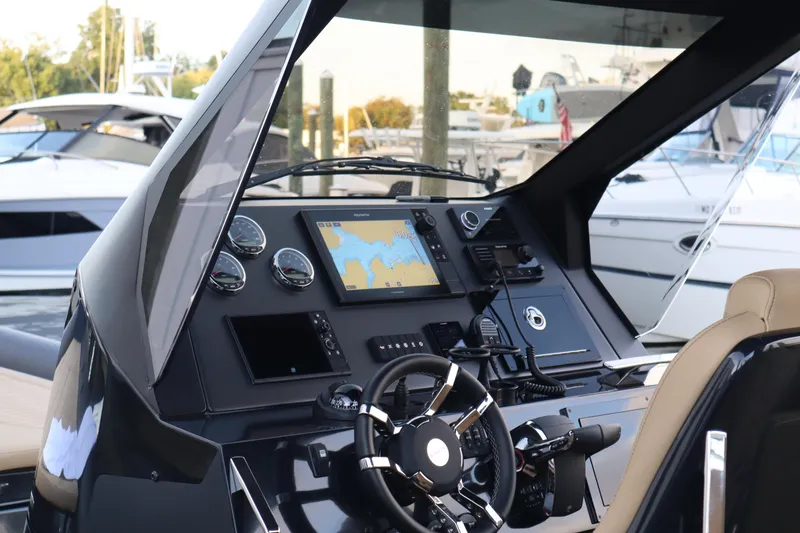 Slide: The Image of 2023 Ribco Seafarer 36 X helm with navigation display and controls at marina. - 20