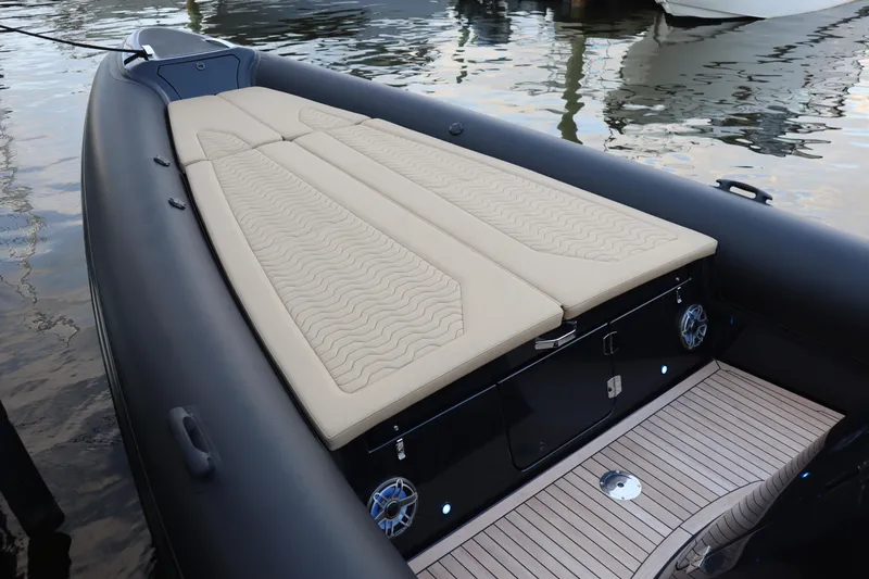 Slide: The Image of 2023 Ribco Seafarer 36 X boat with beige cushioned deck, docked on calm water. - 25