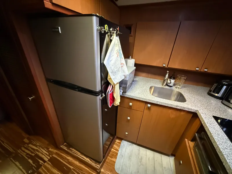 Slide: The Image of Kitchen area of a 1980 Viking 43 Double Cabin with modern appliances and wooden cabinetry. - 27