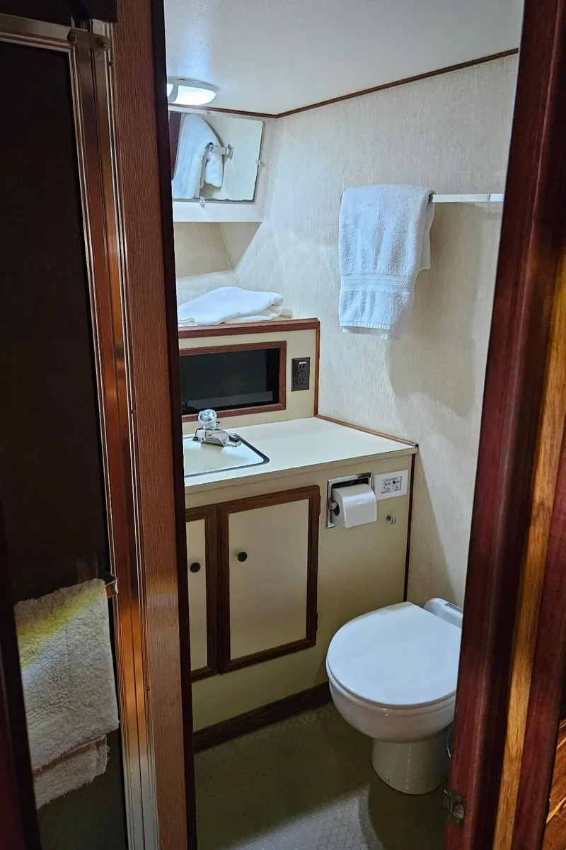 Slide: The Image of 1980 Viking 43 Double Cabin bathroom with sink, toilet, and towel rack. - 32