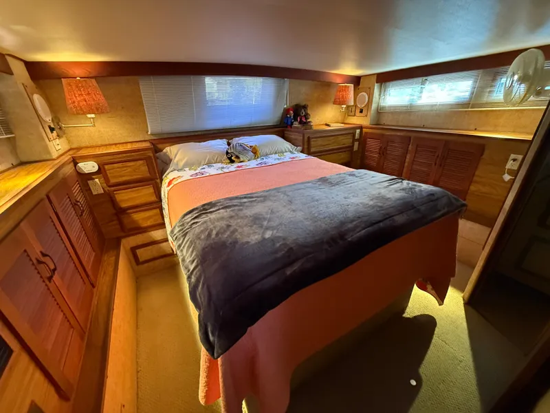 Slide: The Image of Cozy bedroom in 1980 Viking 43 Double Cabin yacht with warm lighting and wooden cabinetry. - 34