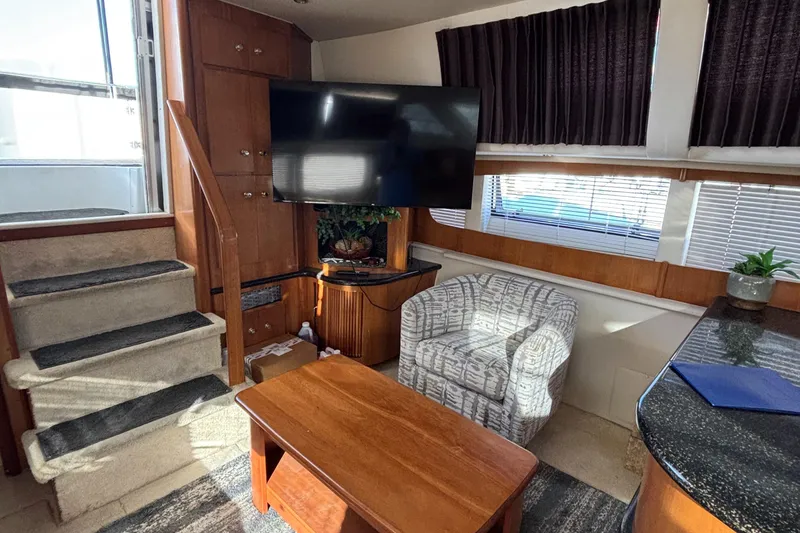 Slide: The Image of Interior of 2001 Carver 396 Aft Cabin MY with TV, chair, and wooden table. - 49