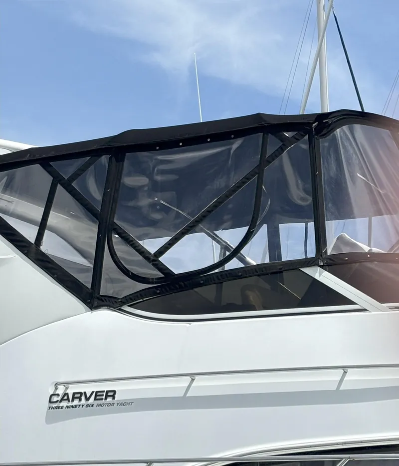Slide: The Image of 2001 Carver 396 Aft Cabin Motor Yacht with black canopy under clear blue sky. - 12