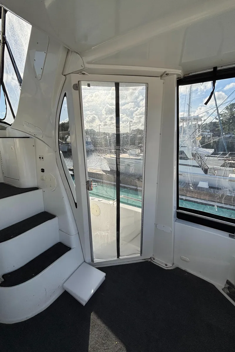 Slide: The Image of Interior view of 2001 Carver 396 Aft Cabin MY yacht with stairs and marina backdrop. - 16