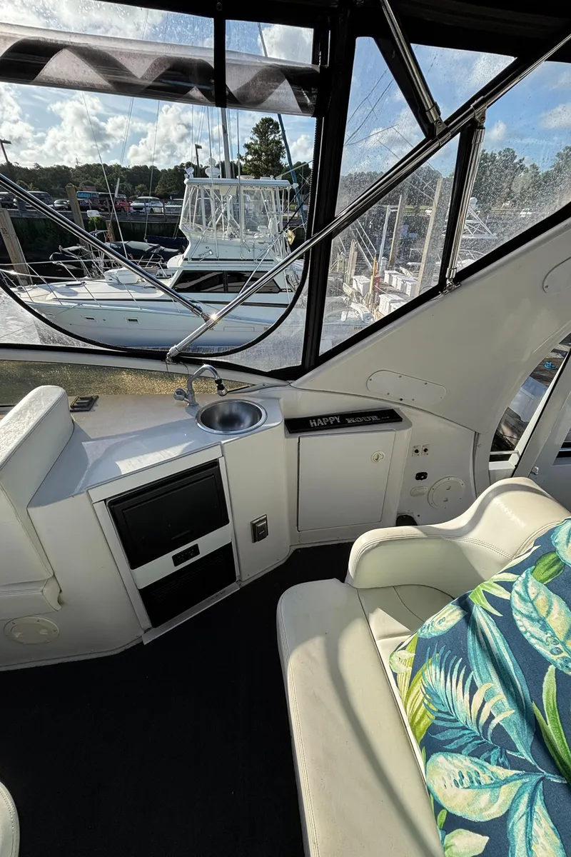 Slide: The Image of 2001 Carver 396 Aft Cabin MY interior with sink, seating, and marina view. - 32
