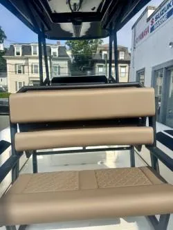 Slide: The Image of 2026 Brig Navigator boat with tan seating, docked near buildings. - 7