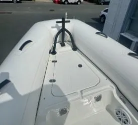 Slide: The Image of 2026 Brig Navigator boat deck, white with black handles, parked outdoors. - 8