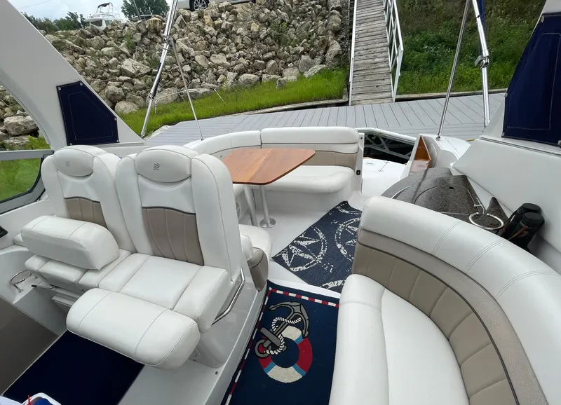 Slide: The Image of 2006 Four Winns 318 Vista boat interior with white seating and wooden table. - 14