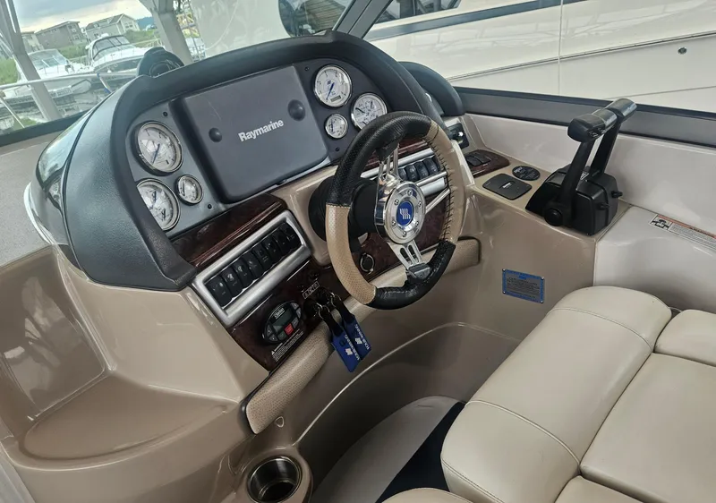 Slide: The Image of 2006 Four Winns 318 Vista boat cockpit with Raymarine navigation system and leather steering wheel. - 15
