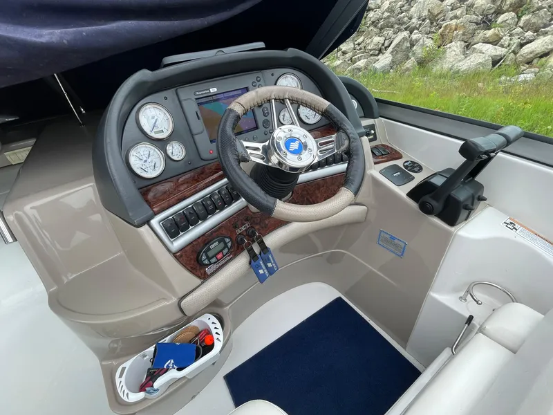 Slide: The Image of 2006 Four Winns 318 Vista boat dashboard with steering wheel and navigation controls. - 16