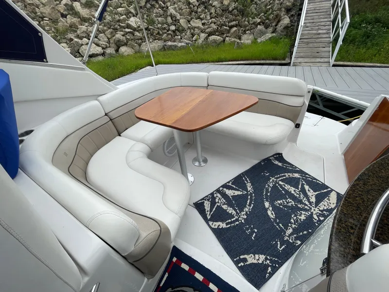 Slide: The Image of 2006 Four Winns 318 Vista boat interior with white seating and wooden table. - 18