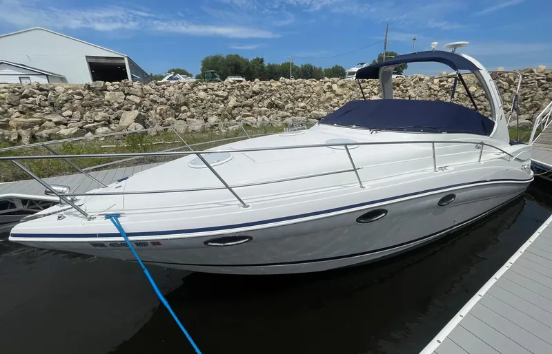 Slide: The Image of 2006 Four Winns 318 Vista boat docked, featuring sleek design and white exterior. - 2