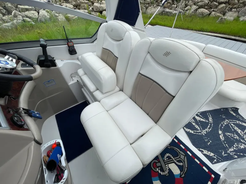Slide: The Image of 2006 Four Winns 318 Vista boat interior with white leather seating and steering area. - 22