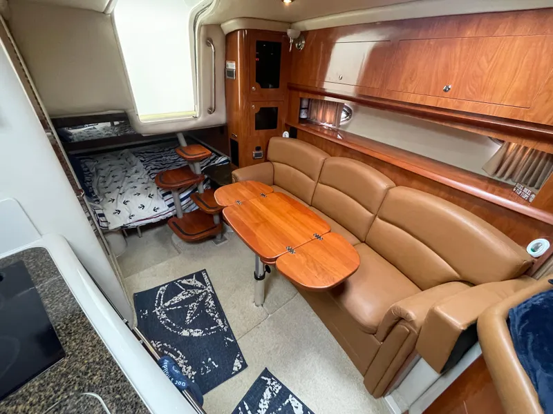 Slide: The Image of 2006 Four Winns 318 Vista interior with leather seating, wooden table, and cozy sleeping area. - 24