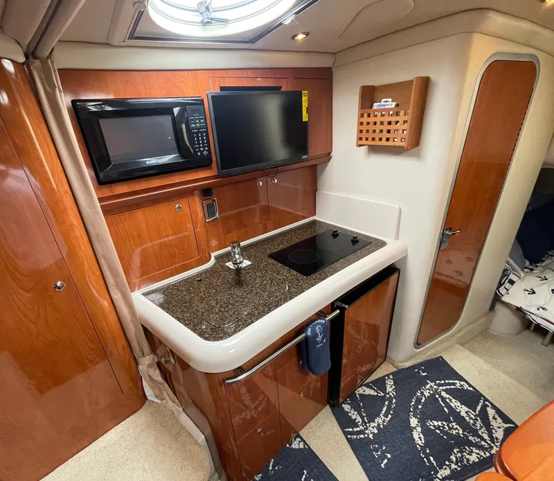 Slide: The Image of 2006 Four Winns 318 Vista yacht interior with kitchenette, microwave, and TV. - 26