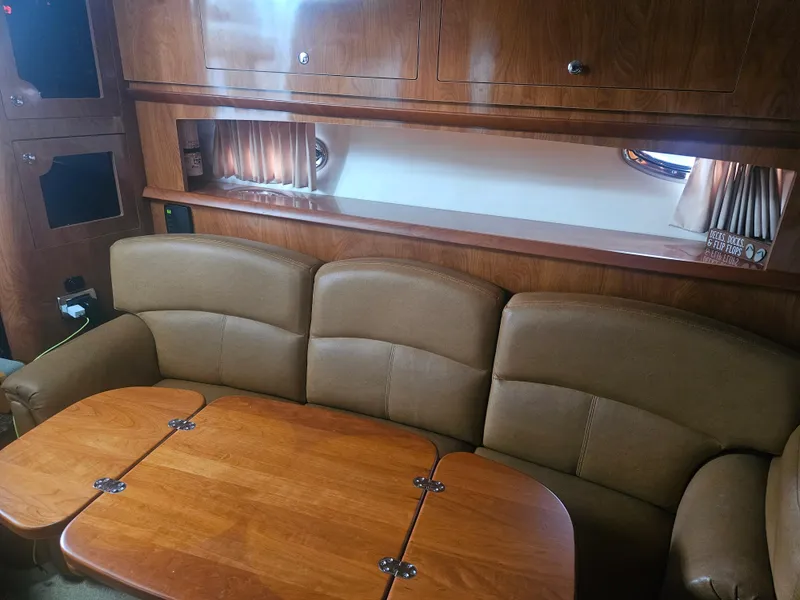 Slide: The Image of Interior of 2006 Four Winns 318 Vista boat with brown leather seating and wooden table. - 27