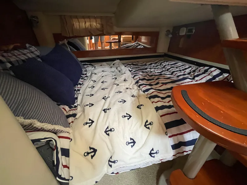 Slide: The Image of Cozy cabin interior of 2006 Four Winns 318 Vista with nautical-themed bedding. - 30