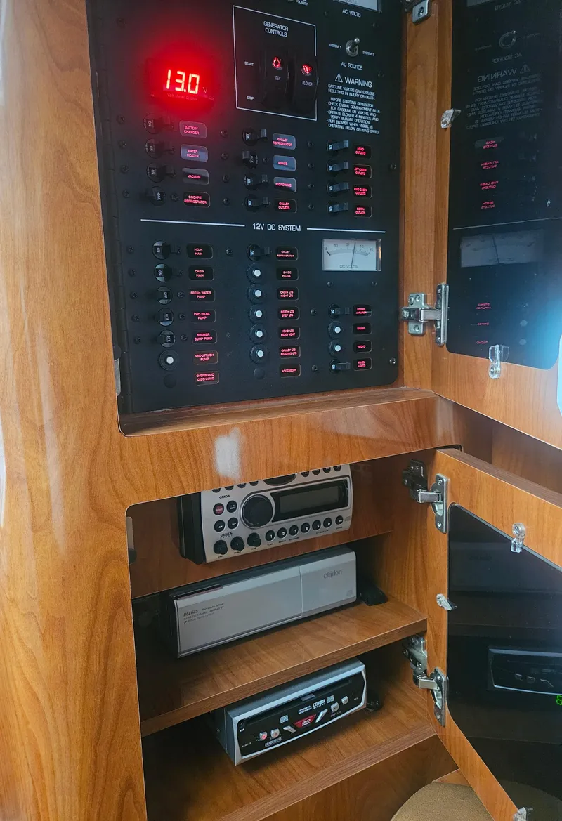 Slide: The Image of Electrical control panel in a 2006 Four Winns 318 Vista boat, featuring wood cabinetry. - 31