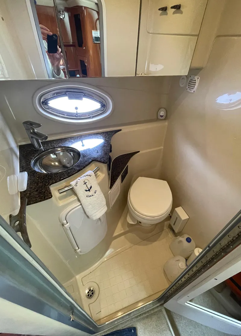 Slide: The Image of Compact bathroom in 2006 Four Winns 318 Vista boat with sink, toilet, and storage. - 32