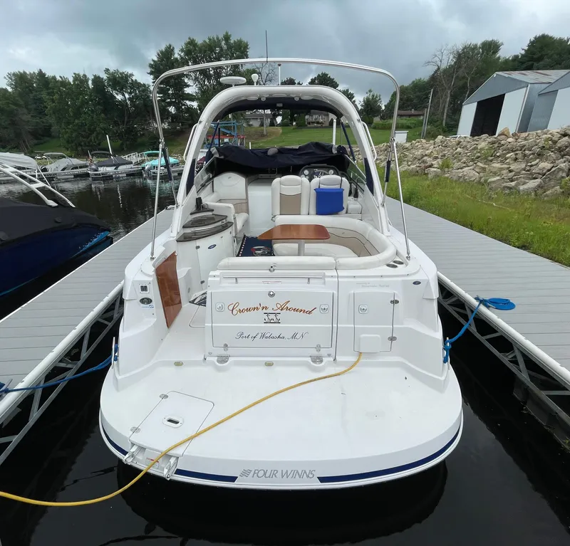 Slide: The Image of 2006 Four Winns 318 Vista boat docked at marina, overcast sky, lush greenery. - 7
