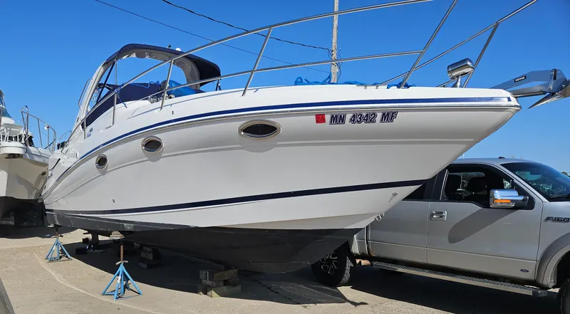 Slide: The Image of 2006 Four Winns 318 Vista boat on stands beside a truck, clear blue sky. - 8