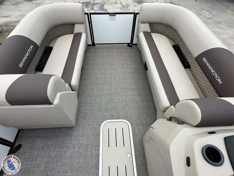 Slide: The Image of 2025 Bennington 21 SL pontoon boat interior with beige and brown seating, spacious layout. - 3