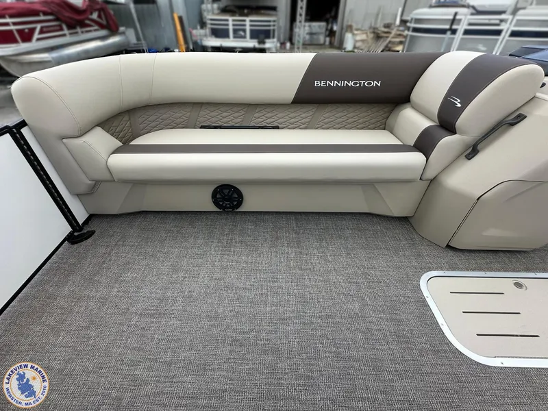 Slide: The Image of 2025 Bennington 21 SL boat interior with beige seating and carpeted flooring. - 4