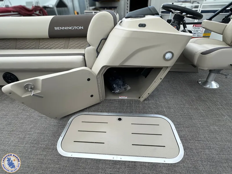 Slide: The Image of 2025 Bennington 21 SL boat interior with open storage compartment and steering console. - 8