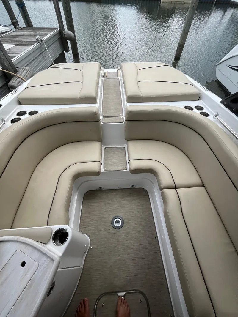 Slide: The Image of 2015 Rinker 276 Captiva Cuddy interior with beige seating and cup holders. - 11