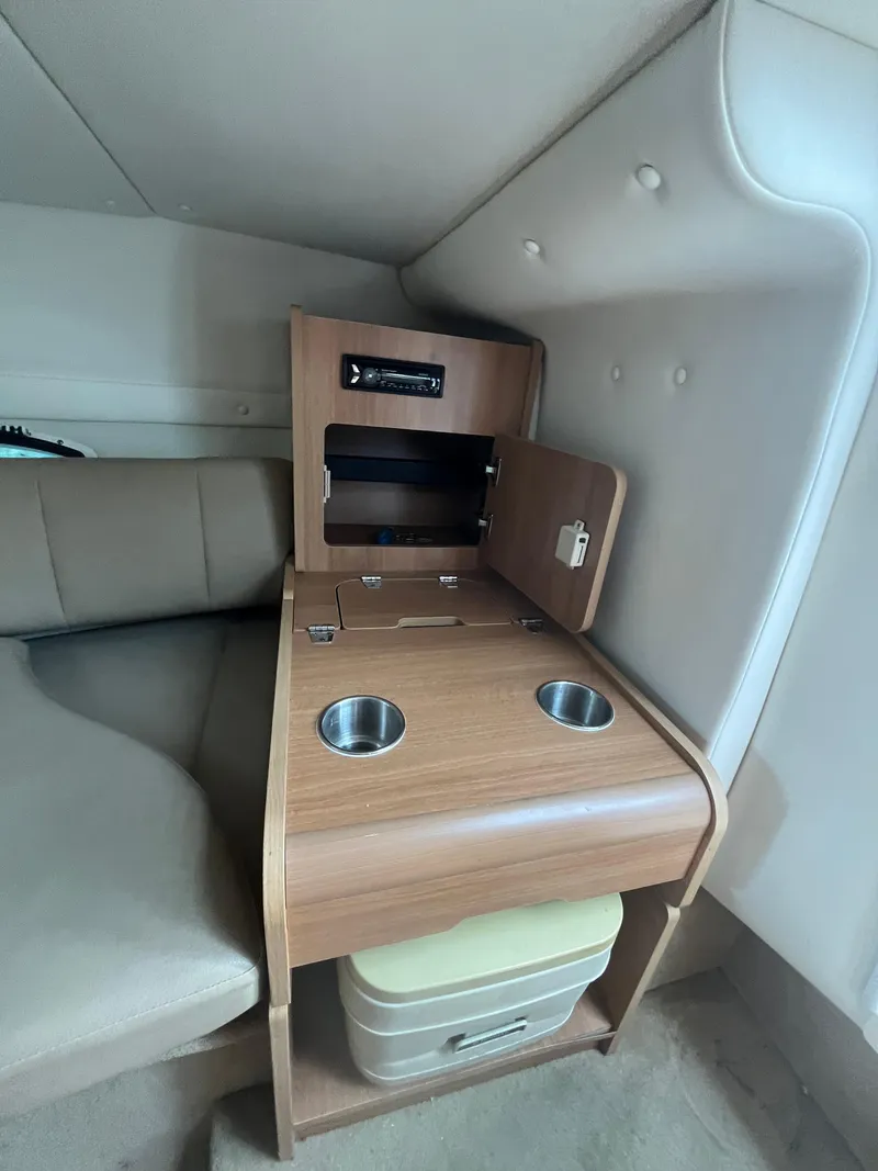 Slide: The Image of 2015 Rinker 276 Captiva Cuddy interior with wooden cabinet and cup holders. - 13