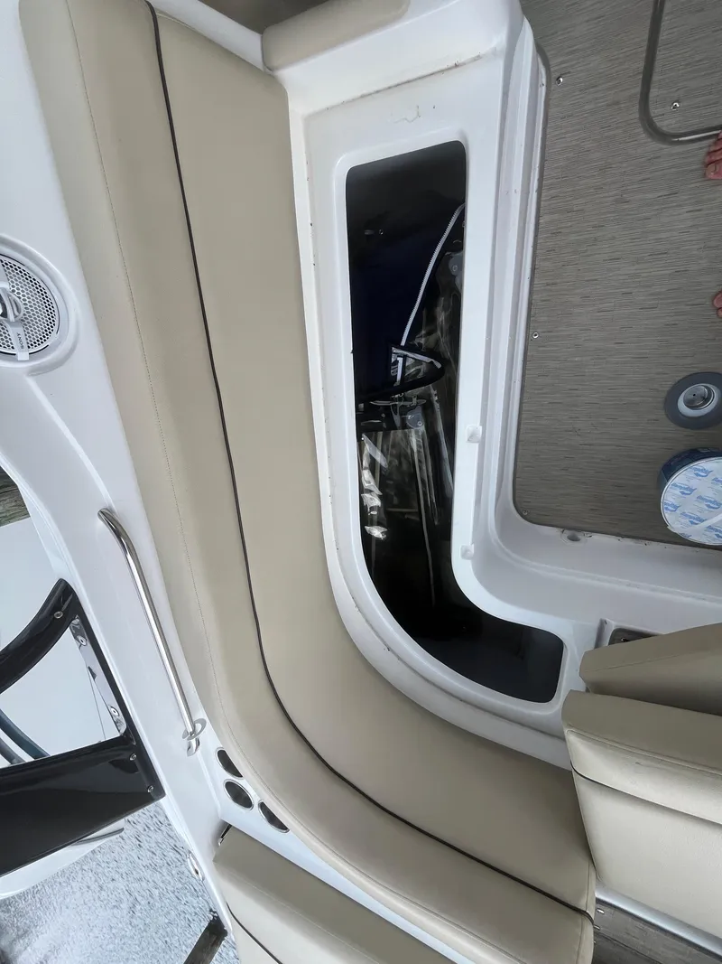 Slide: The Image of Interior view of a 2015 Rinker 276 Captiva Cuddy boat with beige seating and storage compartment. - 5