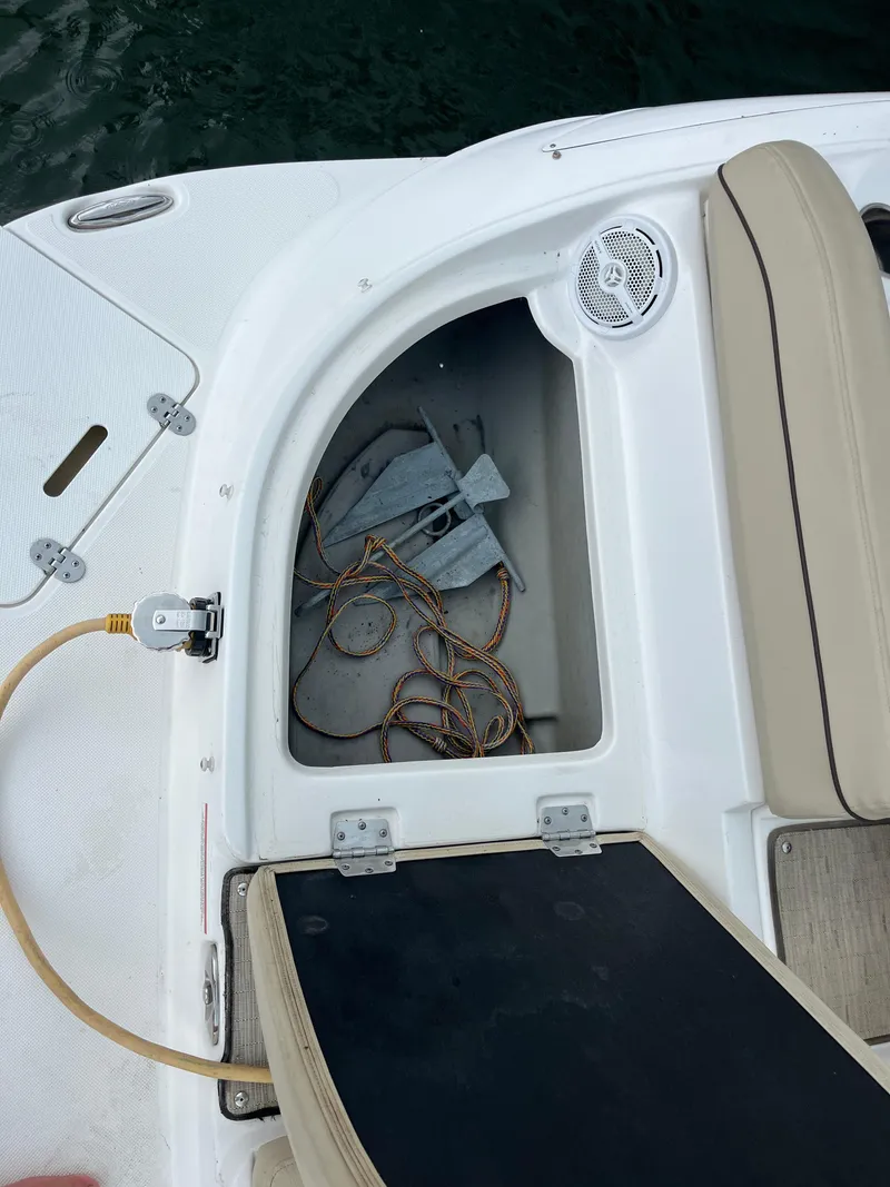 Slide: The Image of 2015 Rinker 276 Captiva Cuddy boat storage compartment with anchor and rope. - 6