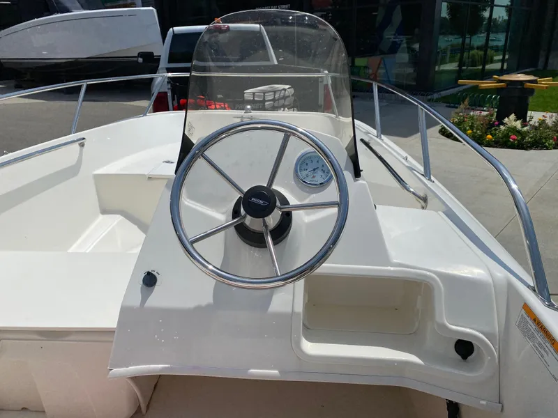 Slide: The Image of 2017 Boston Whaler 150 Super Sport boat steering console with windshield and gauge. - 11