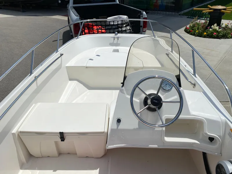Slide: The Image of 2017 Boston Whaler 150 Super Sport boat interior with steering wheel and seating. - 12