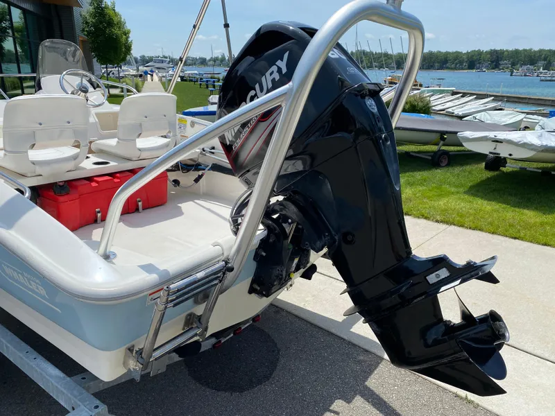 Slide: The Image of 2017 Boston Whaler 150 Super Sport boat with Mercury outboard motor, docked near a marina. - 17