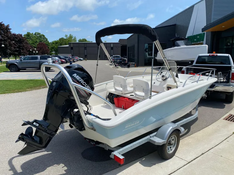 Slide: The Image of 2017 Boston Whaler 150 Super Sport boat on trailer, parked outdoors. - 3