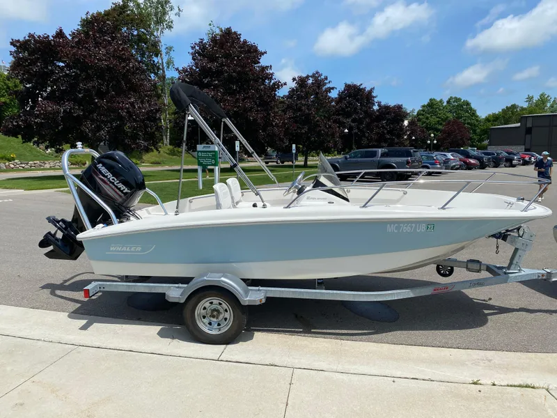 Slide: The Image of 2017 Boston Whaler 150 Super Sport boat on trailer, parked outdoors. - 4