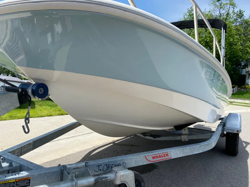 Slide: The Image of 2017 Boston Whaler 150 Super Sport boat on trailer, parked outdoors. - 7