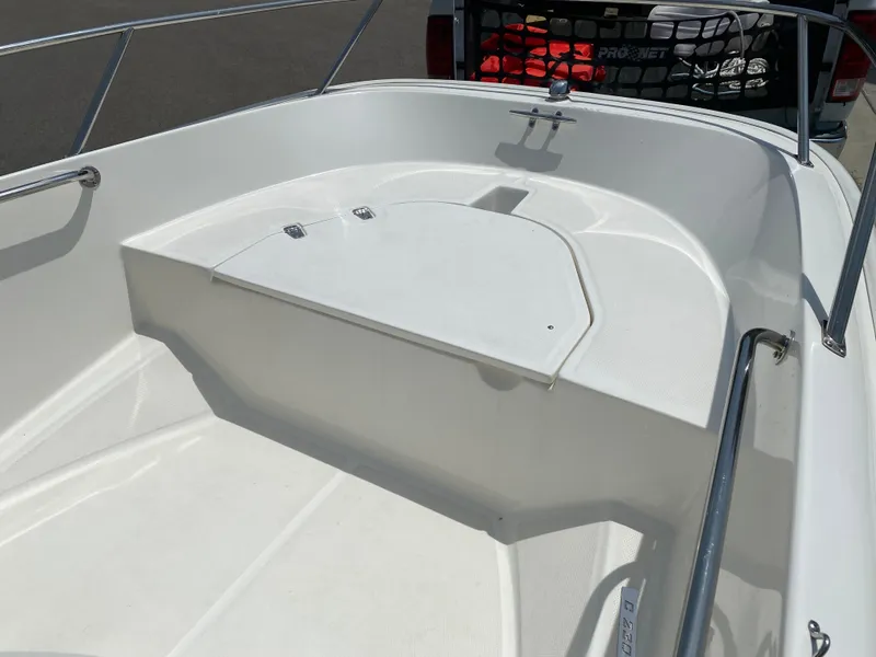 Slide: The Image of 2017 Boston Whaler 150 Super Sport boat interior with white seating and stainless steel railings. - 9