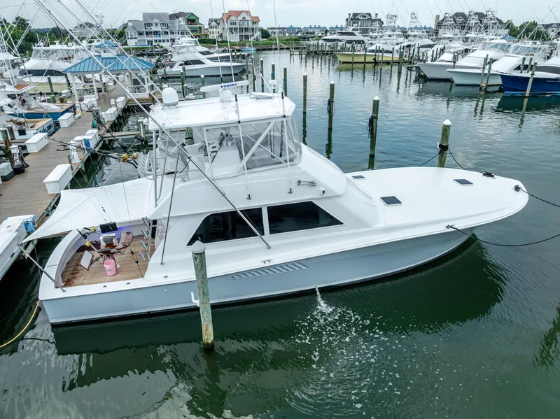 The Image of A 1995 Viking 50 yacht docked in a marina with surrounding boats. - 0
