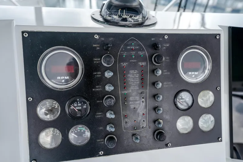 Slide: The Image of Control panel of a 1995 Viking 50 boat with RPM gauges and switches. - 13