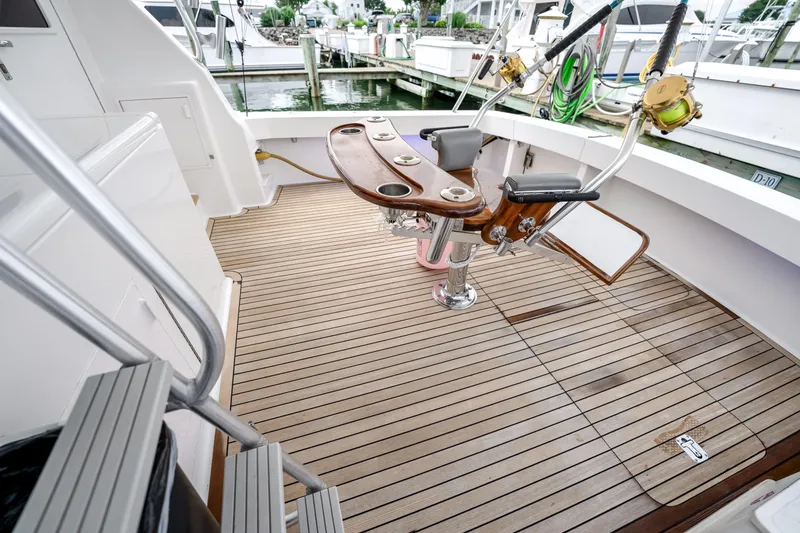 Slide: The Image of 1995 Viking 50 yacht deck with fishing chair and rod holders, docked at marina. - 38