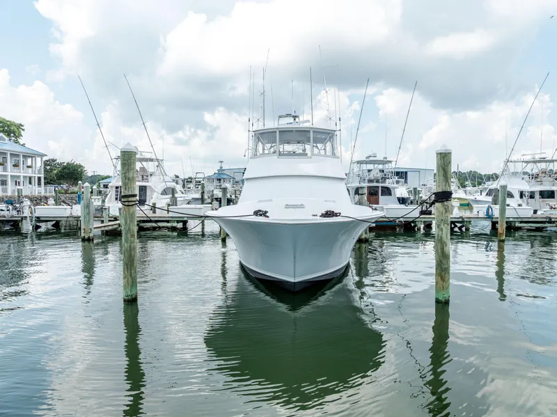 Slide: The Image of 1995 Viking 50 yacht docked at marina, surrounded by other boats under cloudy sky. - 4