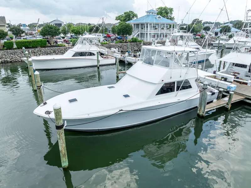 Slide: The Image of 1995 Viking 50 yacht docked at marina, surrounded by other boats and calm water. - 6