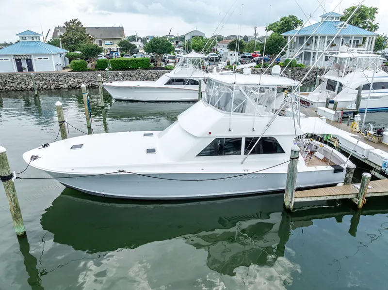 Slide: The Image of 1995 Viking 50 yacht docked at a marina, surrounded by other boats and waterfront buildings. - 7